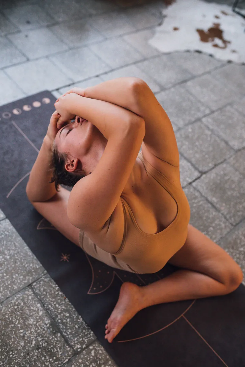 Yoga matında sırt ve omuz esnetme egzersizi yapan kadın